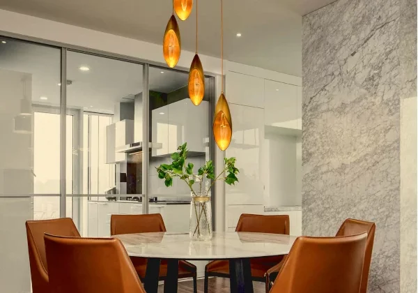 Modern dining area with leather chairs and pendant lights.