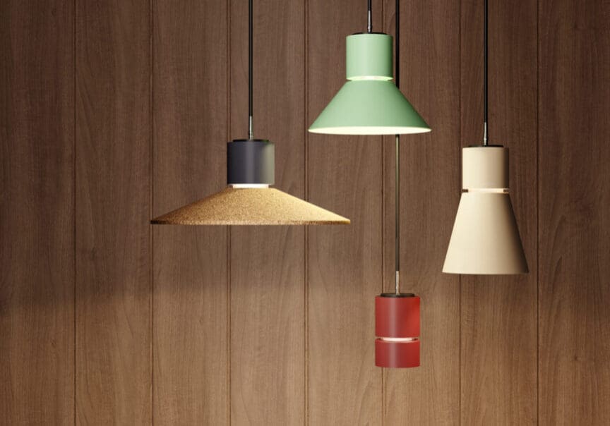 Three modern pendant lamps hanging against a wooden wall.