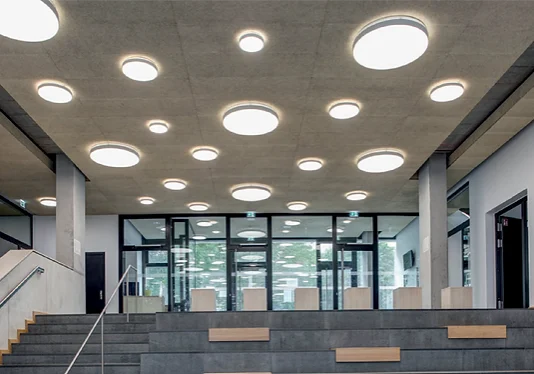 Modern interior with circular ceiling lights and tiered seating.
