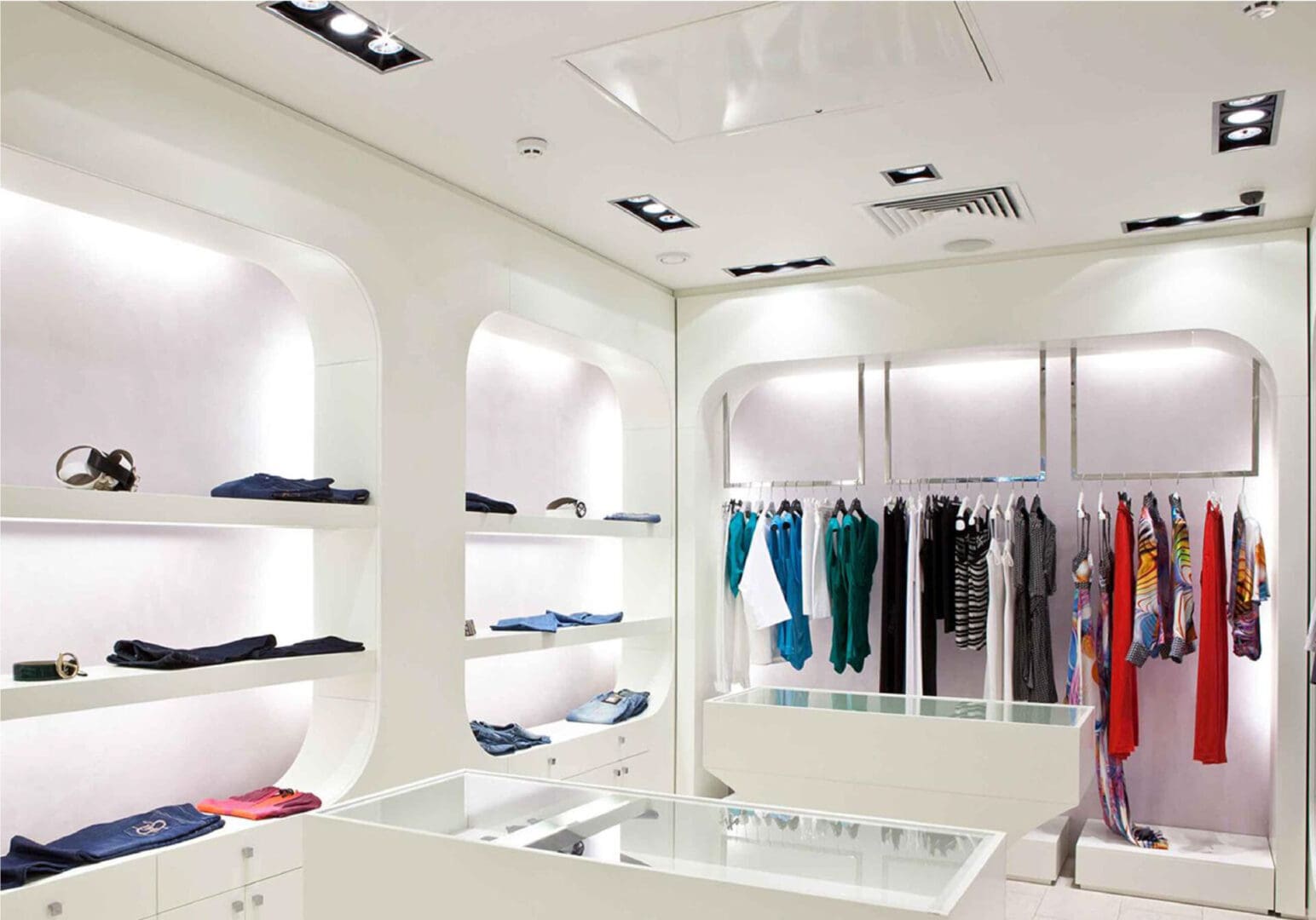 Modern clothing store with bright white interiors and neatly displayed apparel.