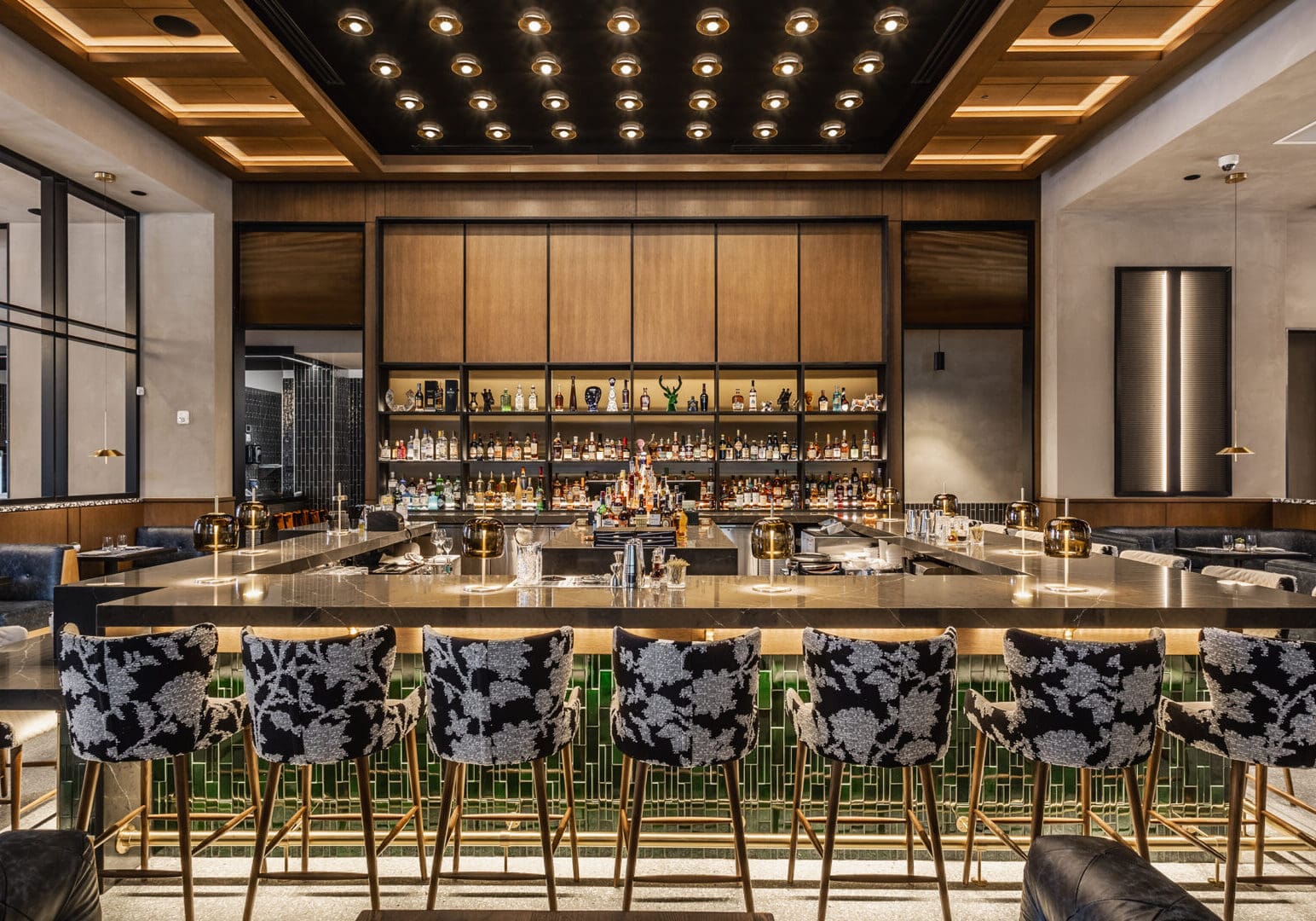 Elegant bar with patterned stools and warm lighting.