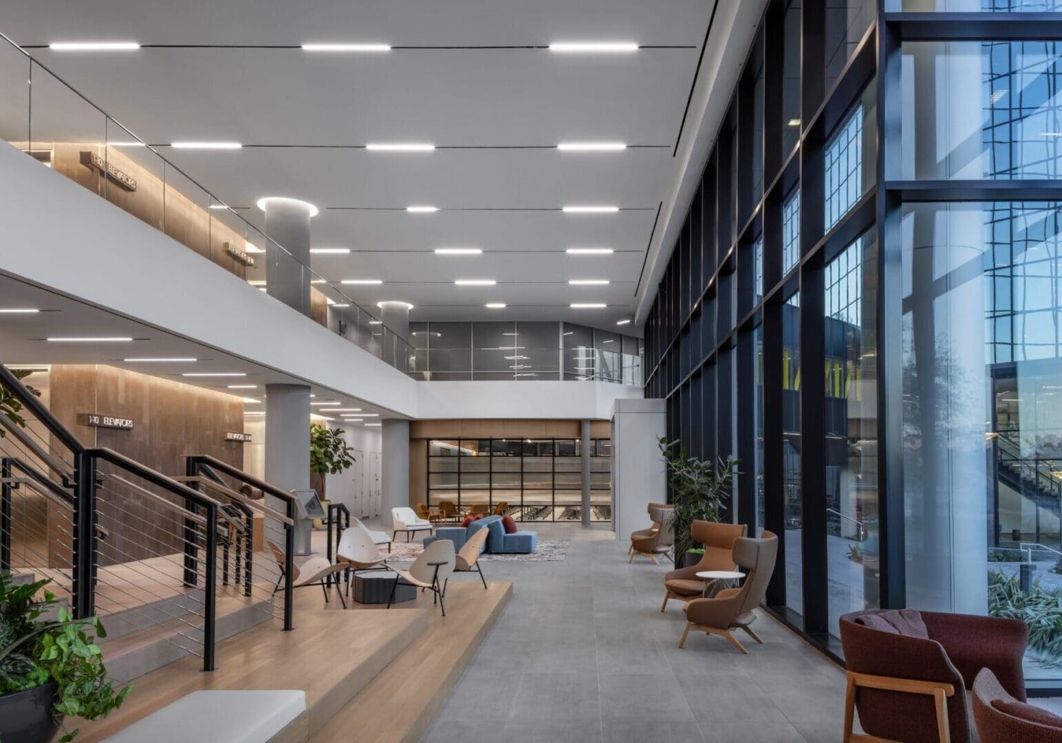 Modern, spacious office lobby with large windows and contemporary furniture.