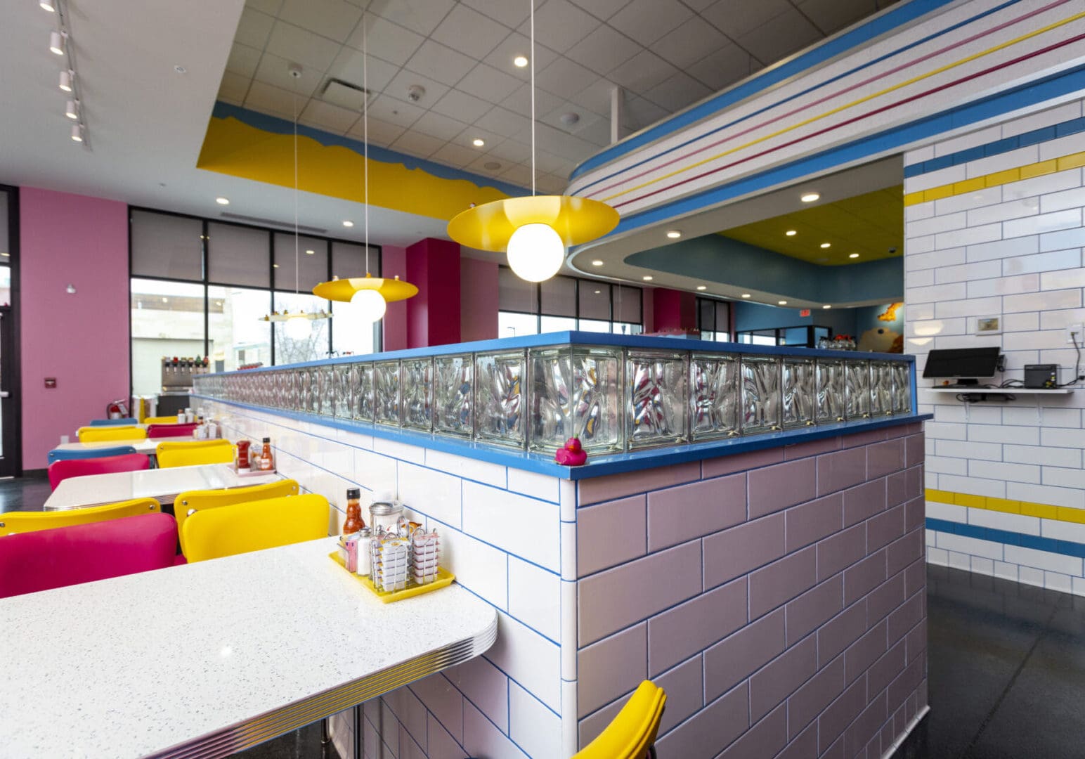 Bright, modern diner interior with colorful seating and geometric patterns.