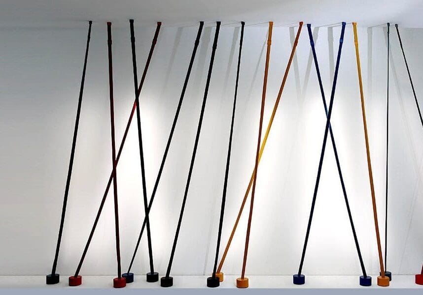 Colorful jump ropes hanging against a white wall.