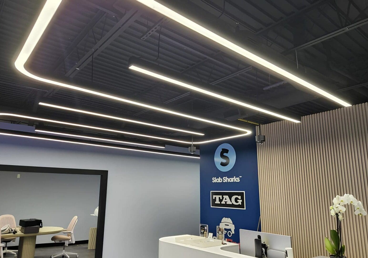 Modern office reception area with sleek lighting and a TAG signage wall.